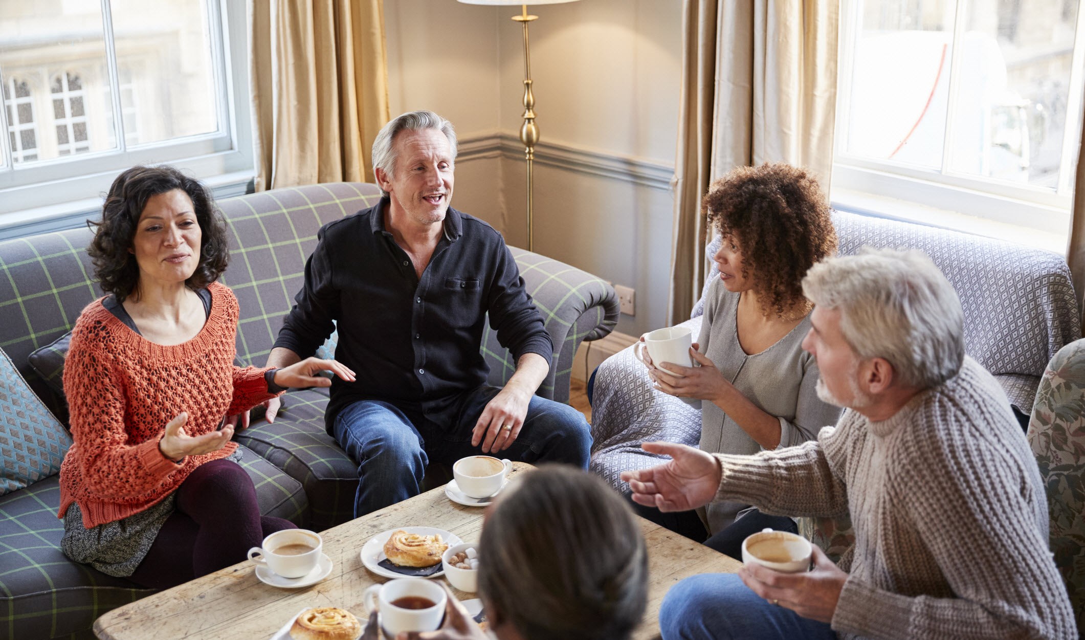 Man with depression sitting with help discussion group at home over coffee