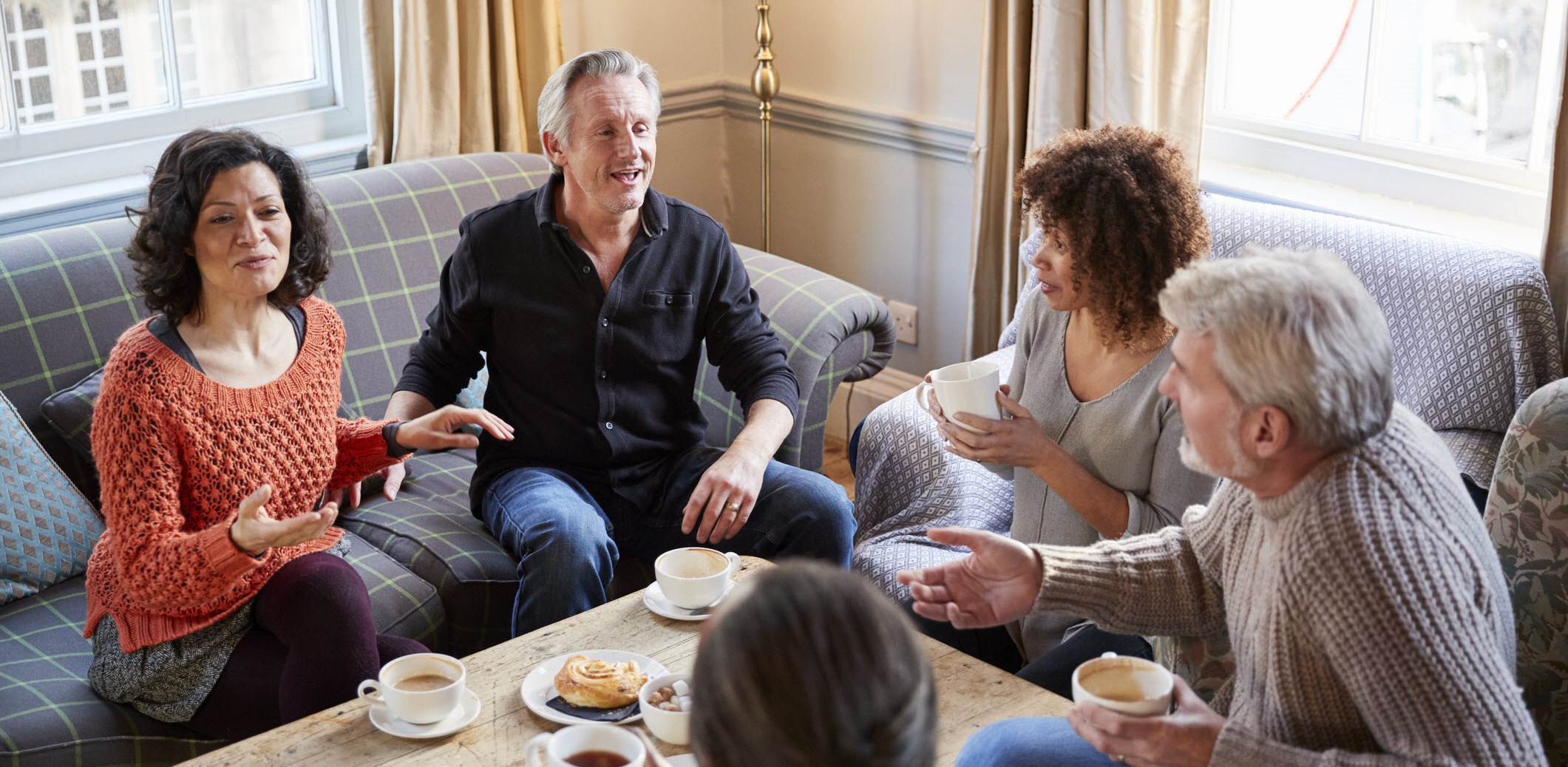 Man with depression sitting with help discussion group at home over coffee