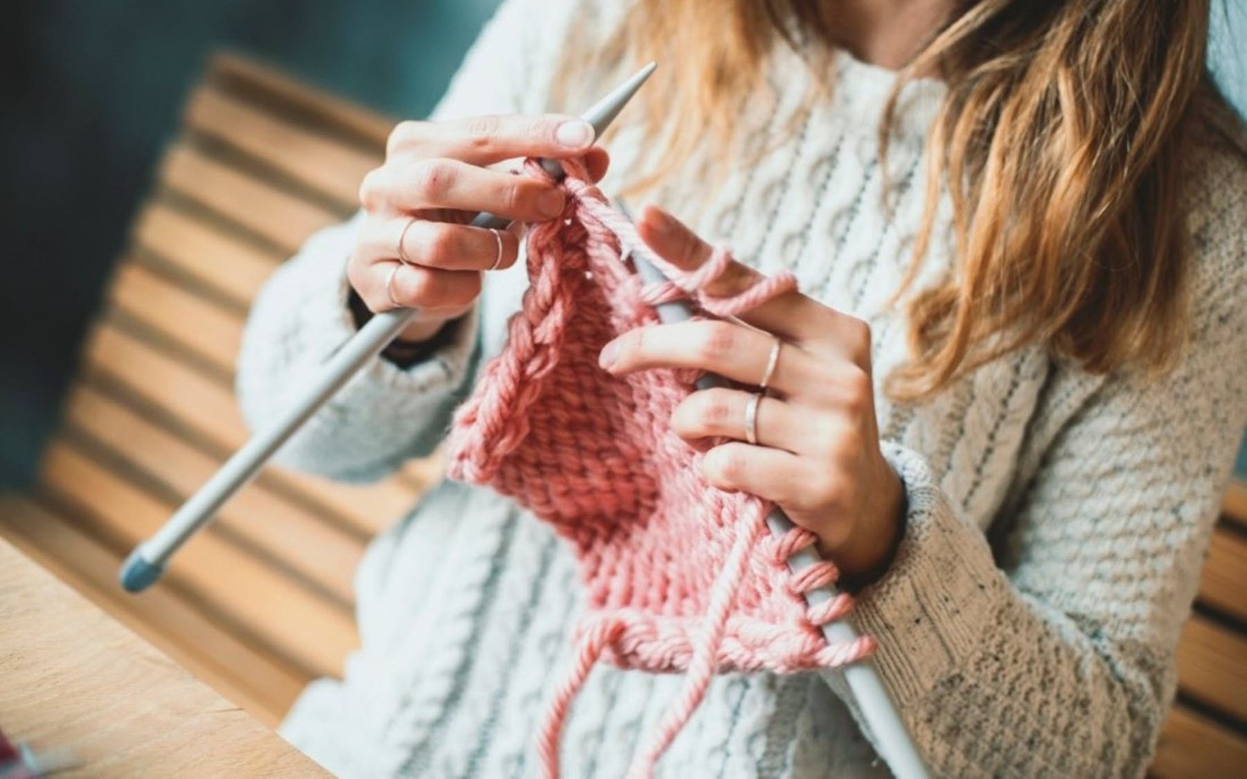 Woman knitting as a distraction from migraine pain 