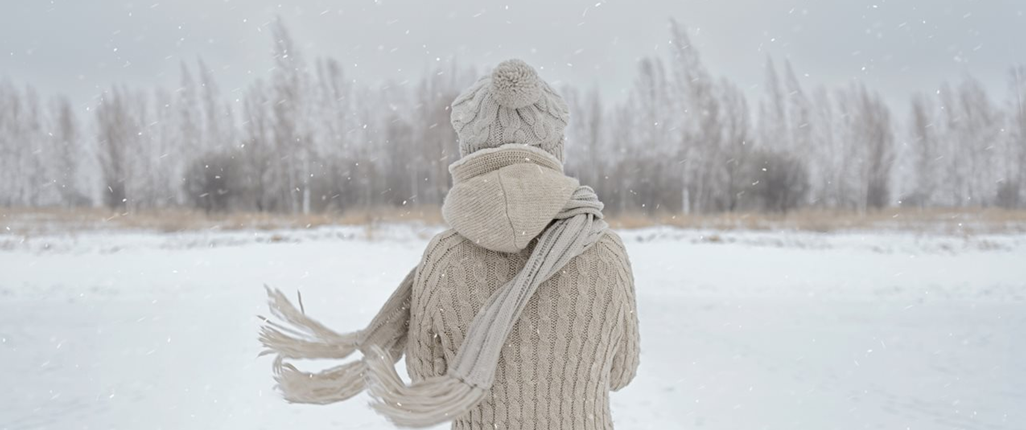 Woman with Christmas depression standing with back to us in the snow